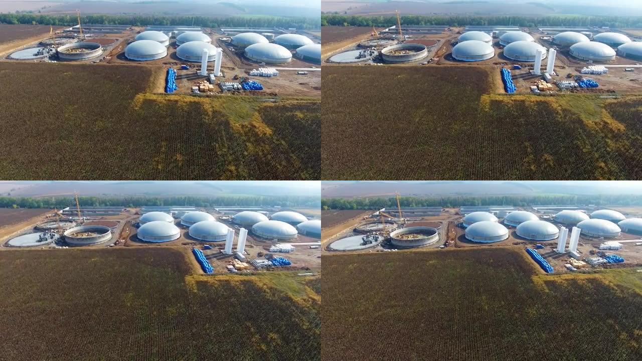 现场沼气厂建设。用于环境中沼气生产的大型储存库。自然中的工业基础设施。鸟瞰图。