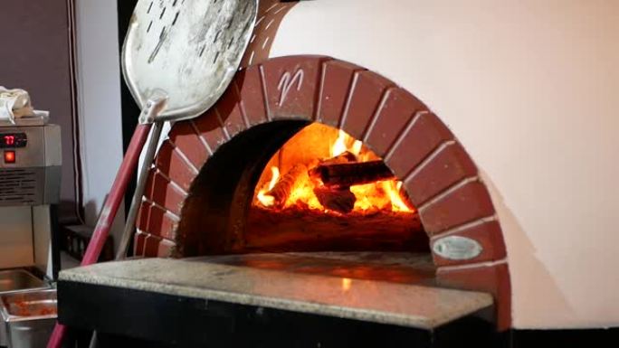 粘土披萨烤箱。炉子里着火了。披萨烤箱。用传统的木烤箱煮披萨。在木架上准备披萨烤箱。五颜六色