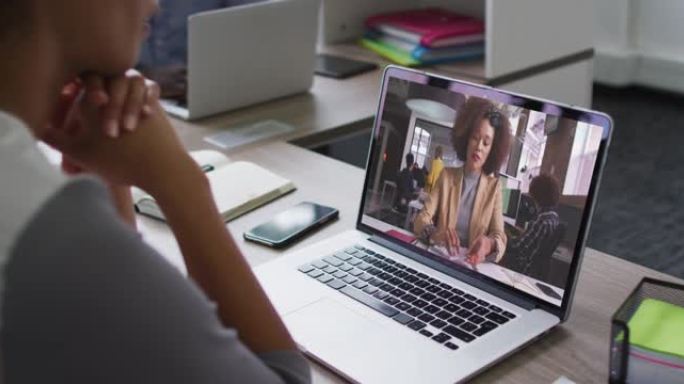 非裔美国妇女在笔记本电脑上与办公室的女同事进行视频会议