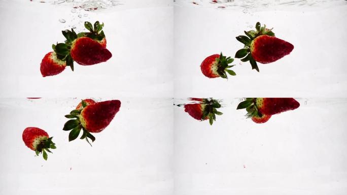 草莓以慢动作飞溅和气泡落入水中。