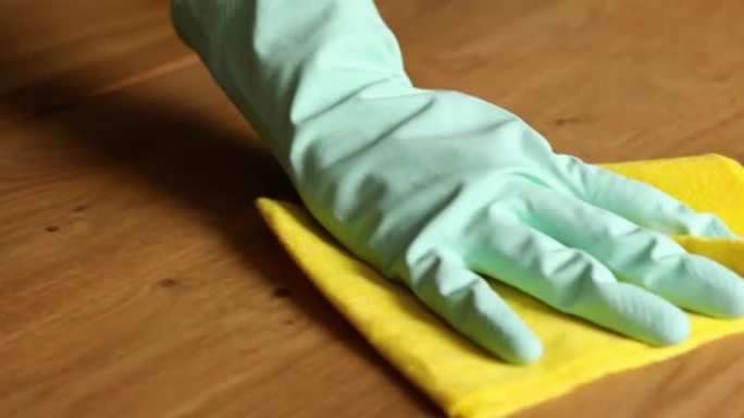 用超细纤维抹布清洁木质桌子表面的乳胶手套无法辨认的女性