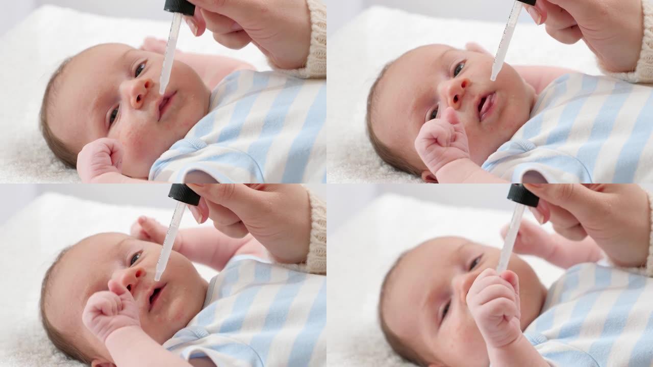 母亲从吸管给刚出生的小儿子服用维生素d和K的特写镜头。婴儿和新生儿疫苗接种和医疗保健的概念。有小孩的