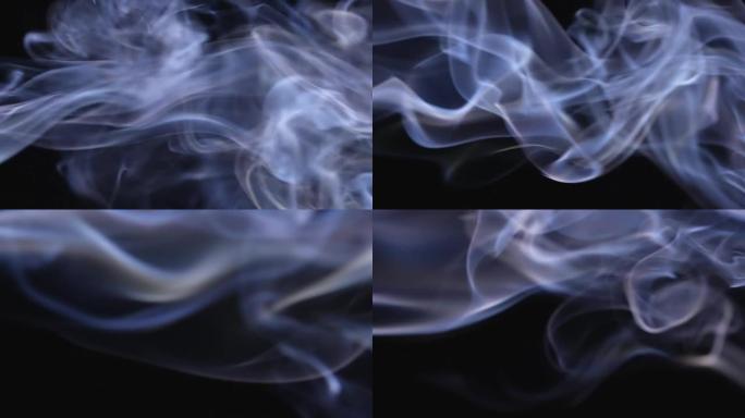 白烟云漂浮在太空中。在慢动作的黑色背景下，烟雾流的漩涡华丽。特写