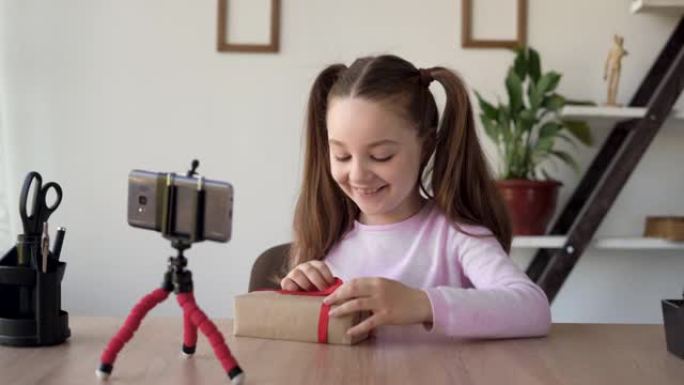 幼儿视频记录器-博客作者在智能手机相机上讲述了为妈妈准备的礼物或生日礼物。博客视频频道用红丝带工艺纸