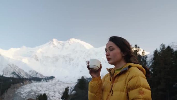女人在巴基斯坦南加帕尔巴特山的背景下喝茶