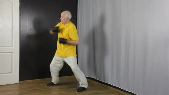 手臂上有黑色护垫的老人运动员在架子上进行运动，拳打脚踢