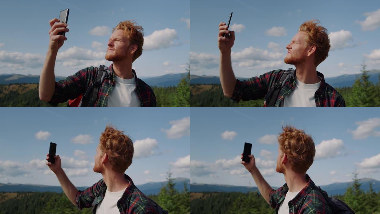 男子在山上捕捉手机信号。手里拿着智能手机的家伙