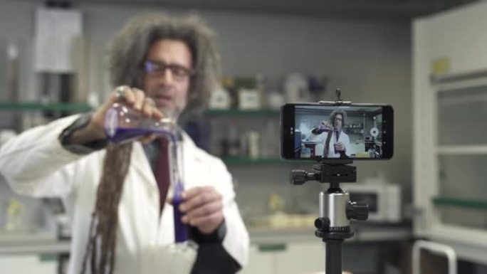 奢侈的教授用智能手机摄像头录制在线视频实验。疯狂教授化学教程vlog