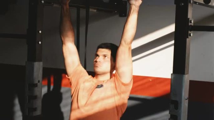 一个年轻强壮的男人在健身房的单杠上锻炼