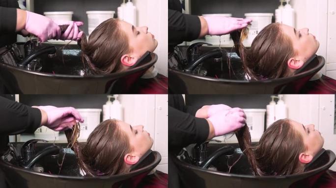 理发师在年轻女子的湿头发上涂润唇膏。