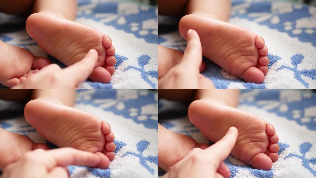 妈妈挠婴儿的脚。特写