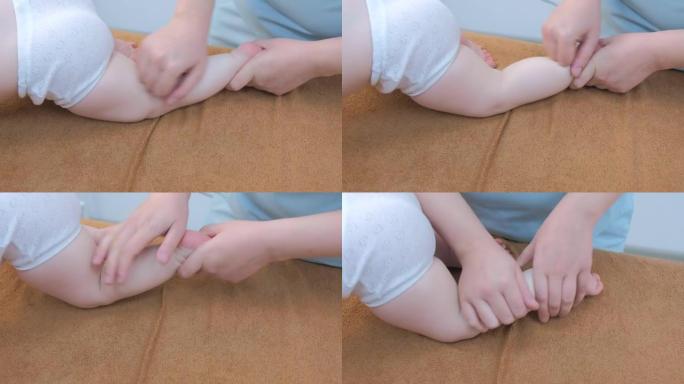 专业医生按摩师在诊所为婴儿做腿部按摩，特写。