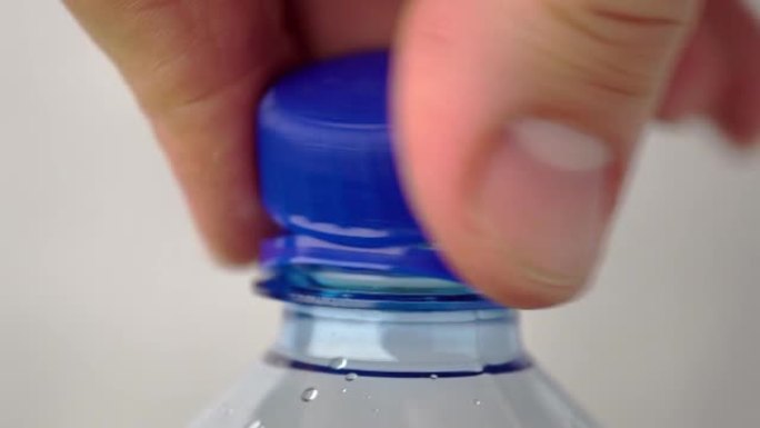 男性手拧下一瓶新的碳酸水塑料瓶的盖子