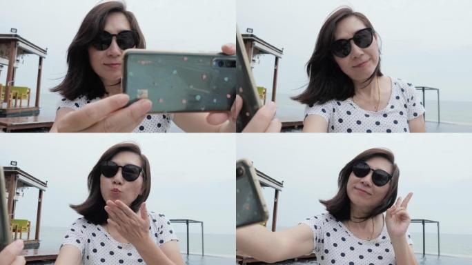 快乐的亚洲女人在游泳池边放松，在酒店度假期间用智能手机自拍照片，生活方式概念。