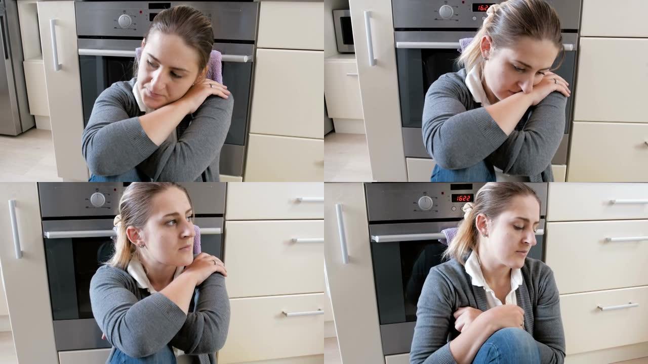 4k特写平移视频悲伤疲惫的年轻女子坐在厨房地板上哭泣