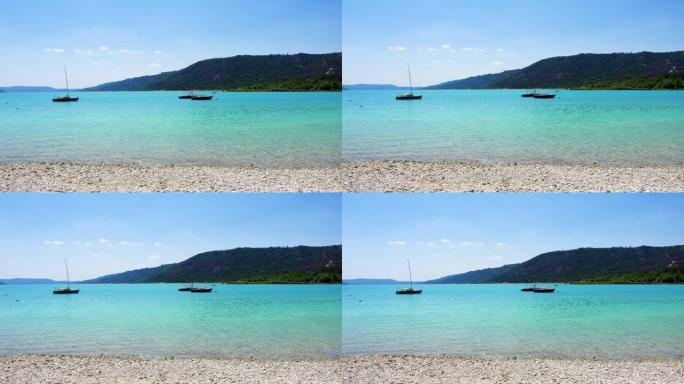 法国普罗旺斯圣克鲁瓦湖的绿松石水。神圣十字湖海滩上的蔚蓝波浪