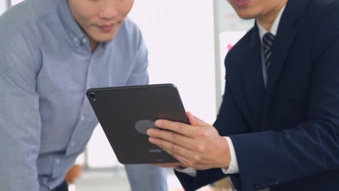 亚洲商人和老板在与团队的办公室会议上使用数字平板电脑讨论项目