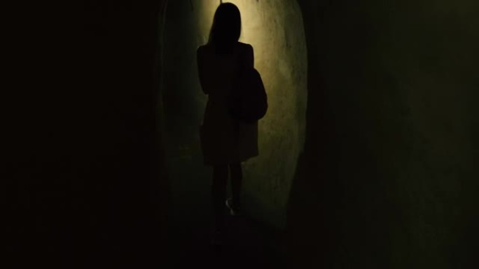 隧道。一个女人走过一条又长又窄的隧道。