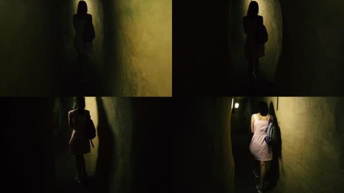 隧道。一个女人走过一条又长又窄的隧道。