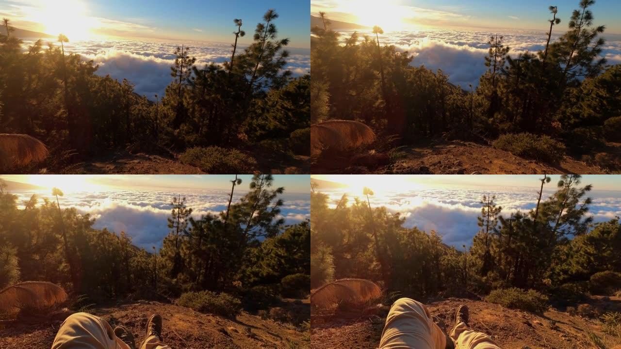 腿放松的观点人坐在地上，看着享受山上的日落-另类冒险的概念户外休闲活动和度假-人们徒步旅行活跃