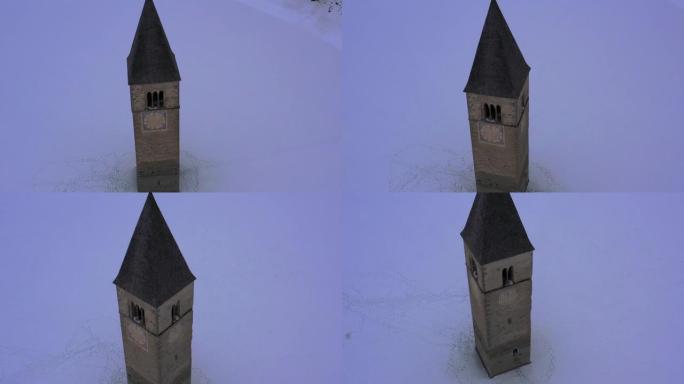 无人驾驶飞机鸟瞰图村庄的旧钟楼从Resia湖中升起