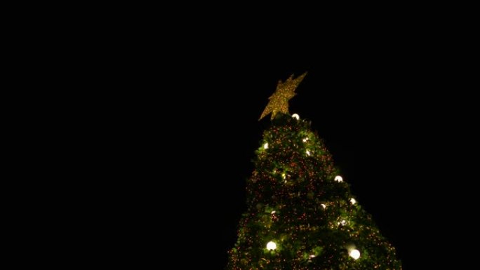 顶部有点火花星的圣诞树，由多色灯装饰