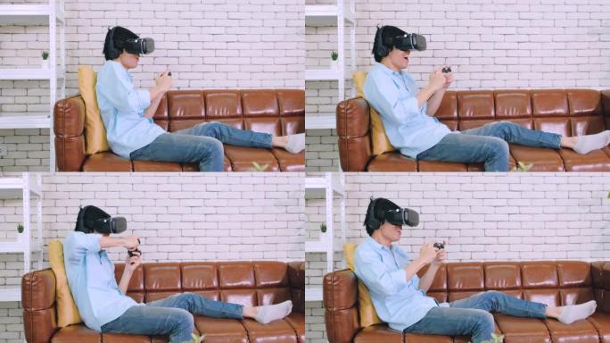 坐在家里客厅沙发上的虚拟现实耳机玩视频游戏的亚洲男人