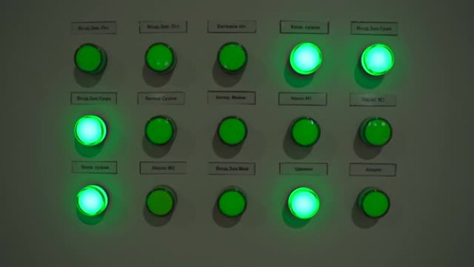制造机械上点亮的绿色按钮灯的特写镜头
