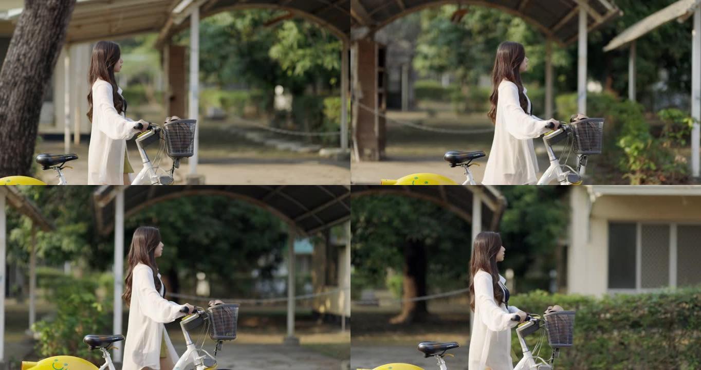 美丽的女孩骑着自行车在城市中旅行。