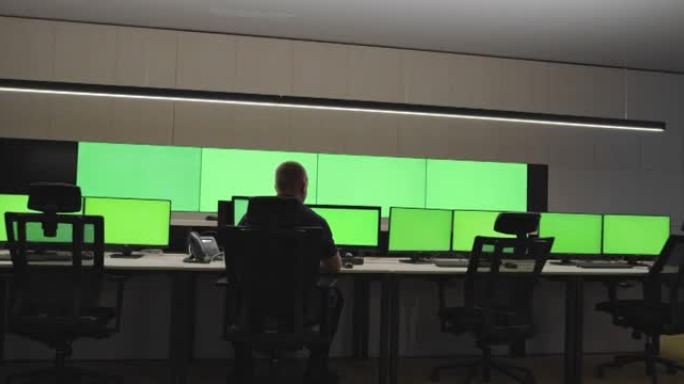 在系统控制中心工作的系统安全专家。房间里充满了绿色屏幕、色度屏幕和安全