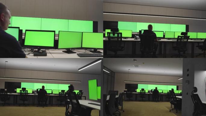 在系统控制中心工作的系统安全专家。房间里充满了绿色屏幕、色度屏幕和安全
