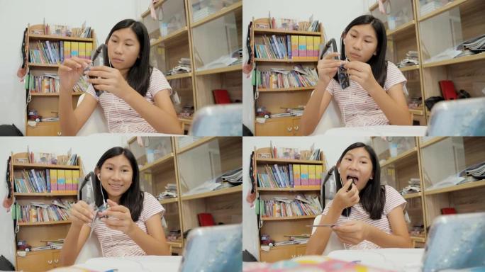 亚洲女学生在新型冠状病毒肺炎期间通过智能手机在家在线学习，社交距离生活方式概念。