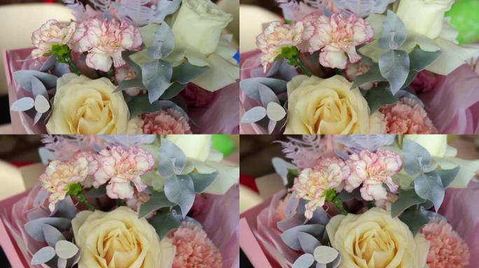 淡黄色，白色和粉红色的花朵花束。玫瑰和康乃馨