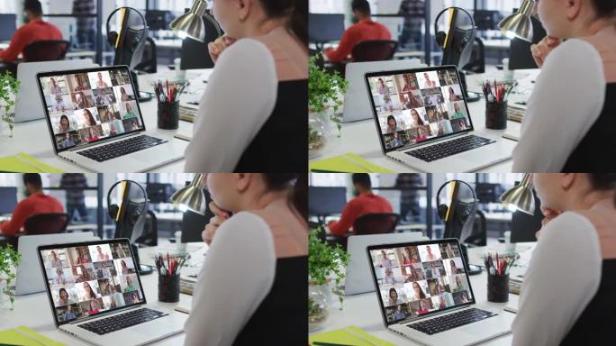 白人妇女在办公室的笔记本电脑上与办公室同事进行视频会议