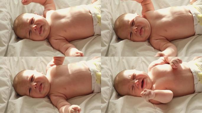 小婴儿新生哭泣，哭泣尖叫，大声哭泣。新生儿在白色毯子上躺在床上又累又饿。婴儿尖叫。健康的小孩出生后不