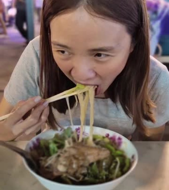 泰国吃面条街食品的女人