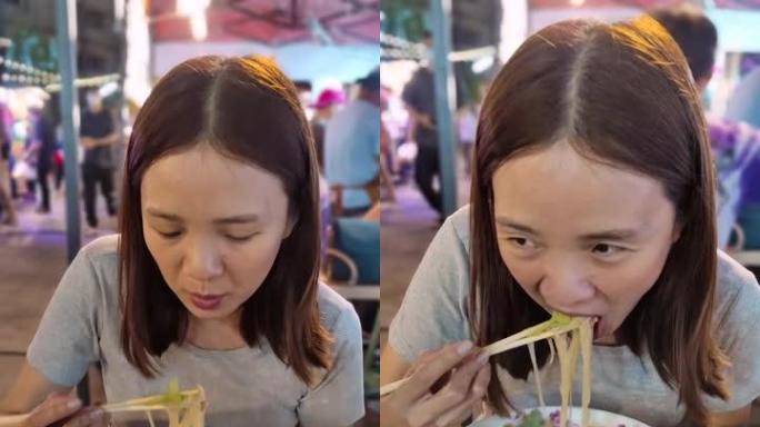 泰国吃面条街食品的女人