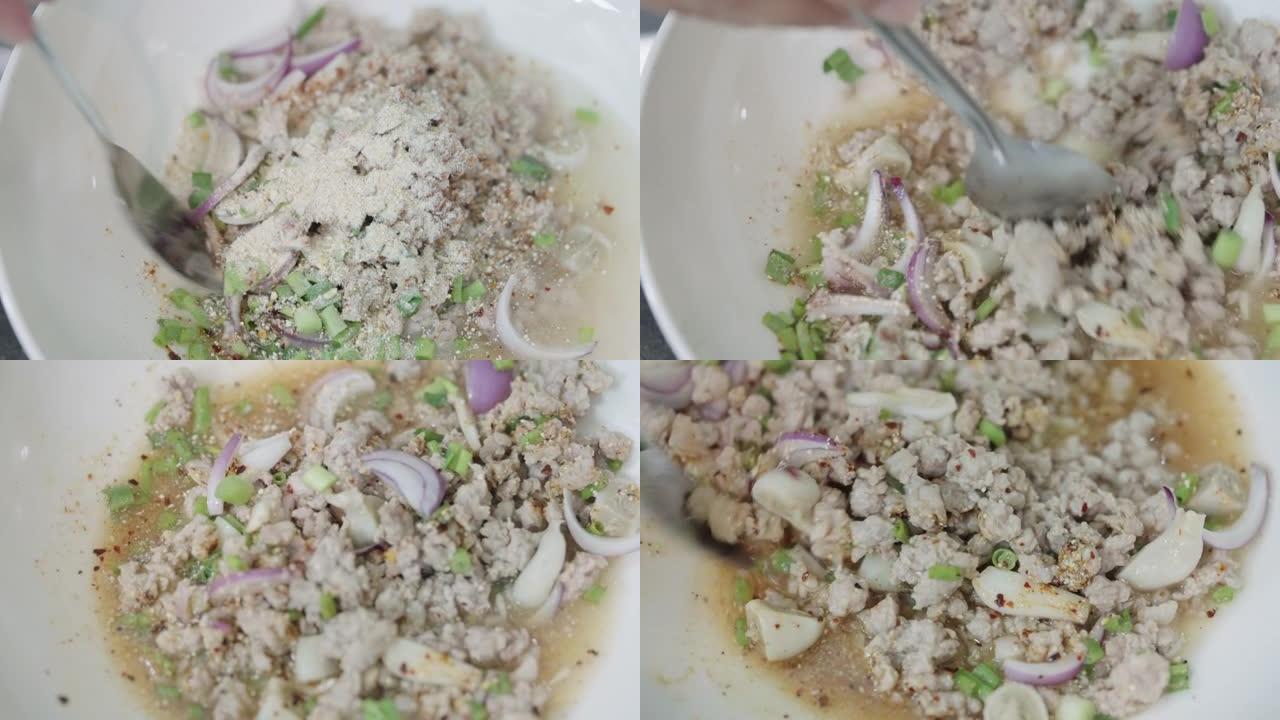 家庭厨师将烤糯米粉放在煮熟的Larb Moo上。
