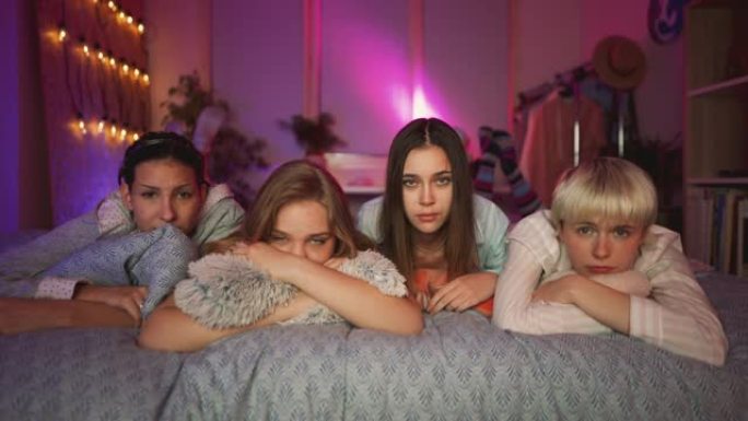 悲伤的年轻女友在过夜时在电视上观看戏剧性的电影