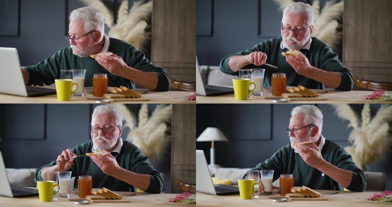 70年代退休男子吃早餐，用笔记本电脑看新闻
