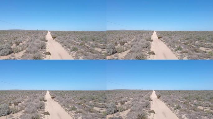 半沙漠景观中薄薄的沙质轨道上的越野车辆在相机下通过