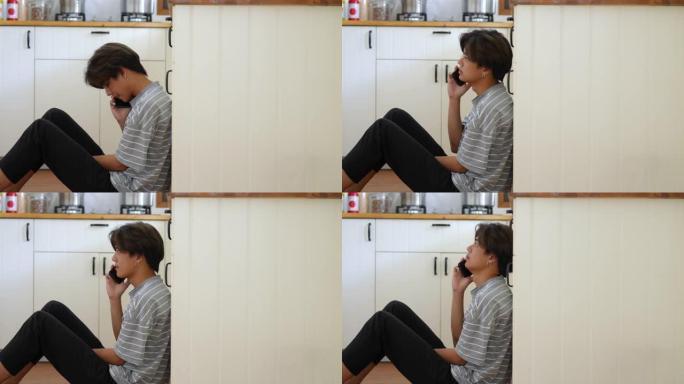 4k强调亚洲男子独自坐在厨房里用手机。