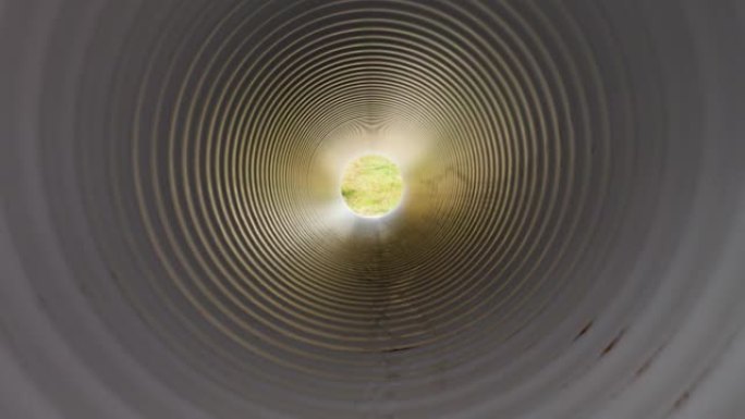 从塑料水管内部观看。隧道尽头的光