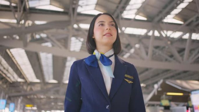 美丽而迷人的高加索空姐工作人员微笑着，带着自信的脸和幸福走在机场航站楼的飞机上。乘务员或女主人职业概