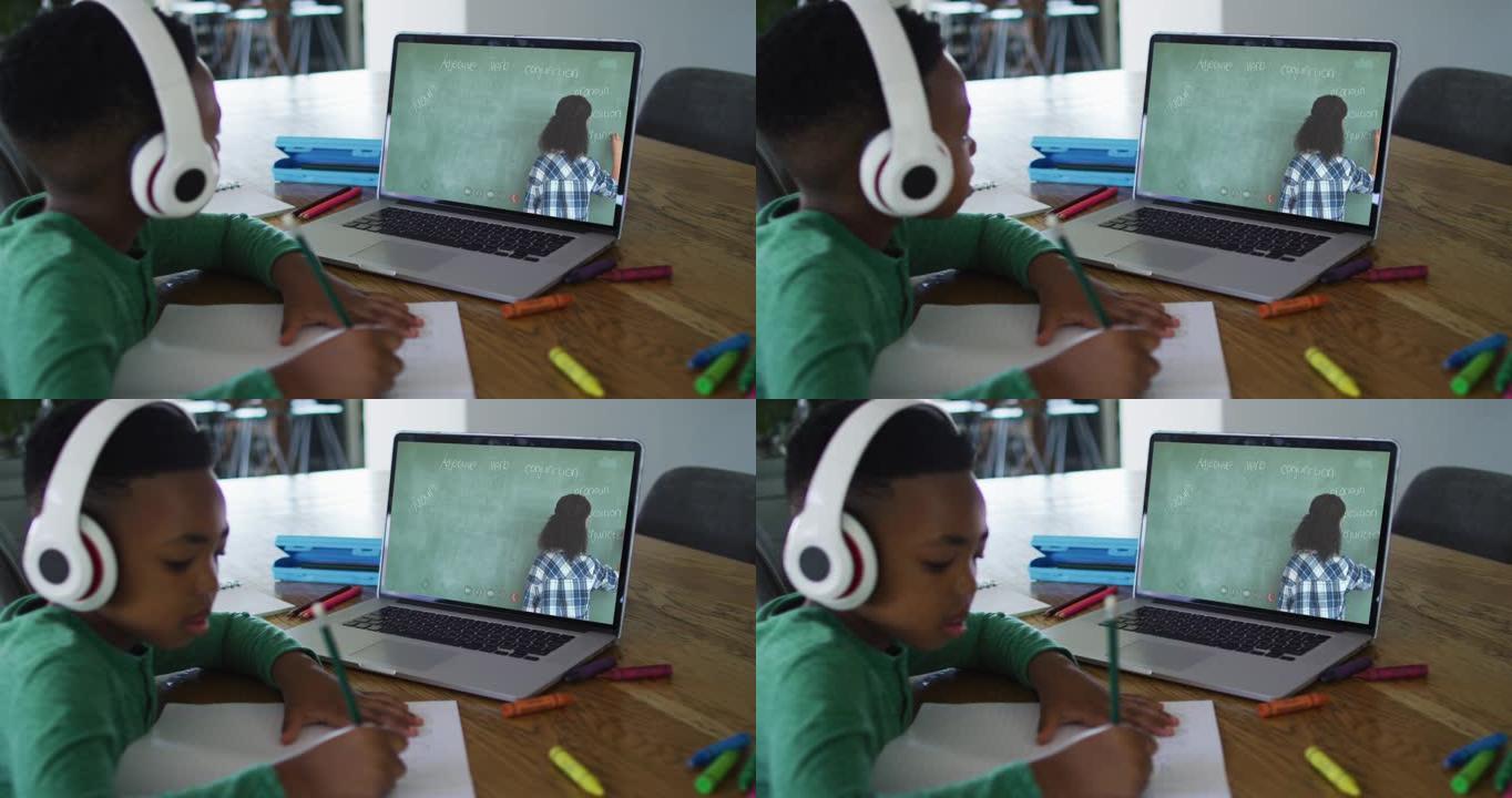 非裔美国男孩在家里用笔记本电脑与女老师进行视频通话时做作业
