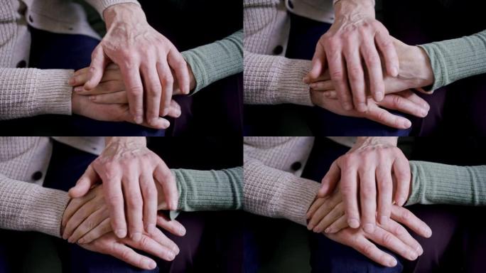 老人的手的特写。一位老人的男性手抚摸一位老人的女人的手，抚慰轻拍。长期婚姻和相互理解的形象。