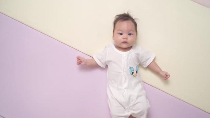 快乐的亚洲婴儿肖像，白色躺在柔和的背景上，有复制空间 ..