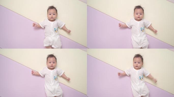 快乐的亚洲婴儿肖像，白色躺在柔和的背景上，有复制空间 ..