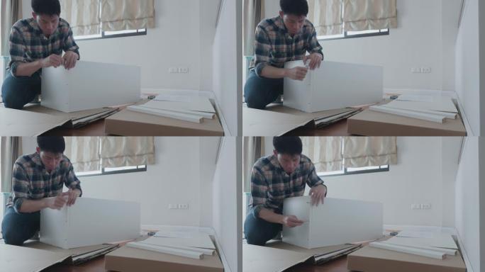 男子组装存储DIY家具在客厅为他的家庭装修