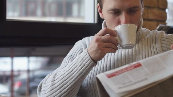 男子在餐馆看报纸，安静地喝咖啡